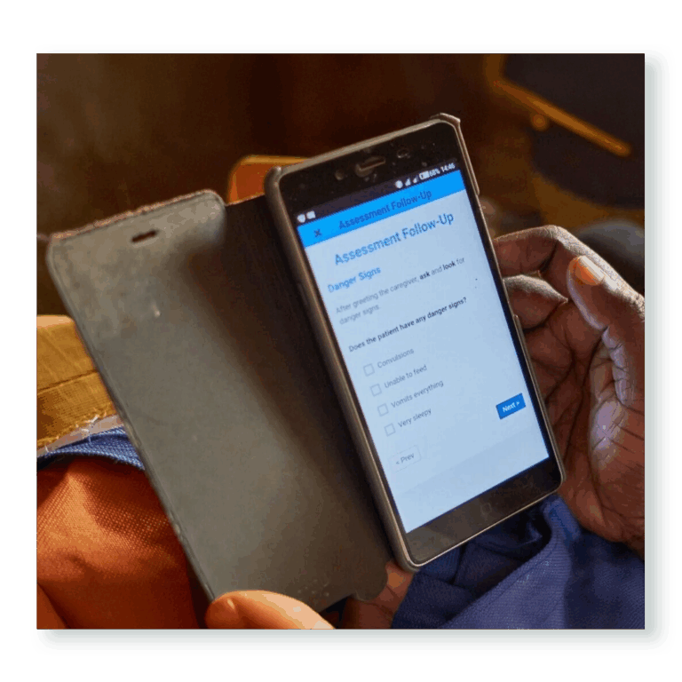 Health worker using a smartphone app to record patient data — part of Edify’s partnership with Medic to strengthen the Community Health Toolkit for reliable care delivery.